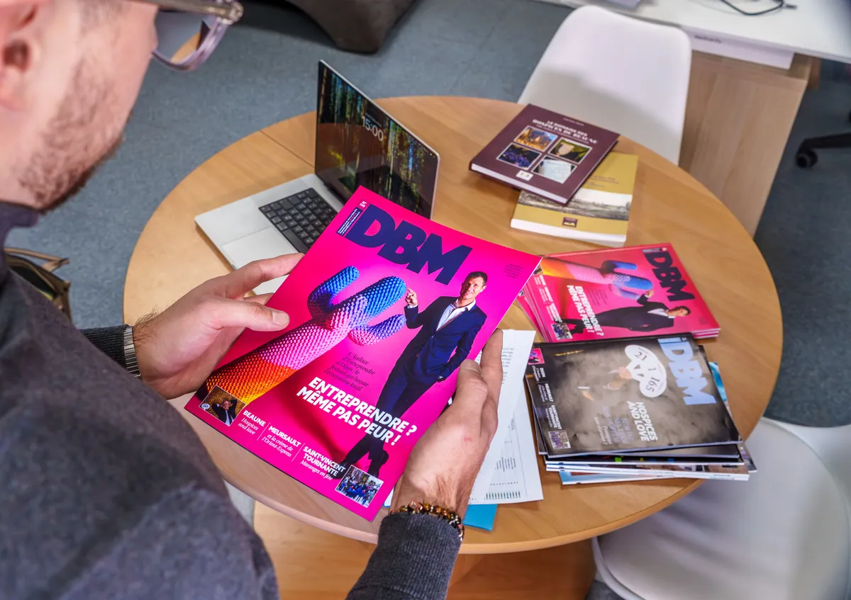 Exemplaire du magazine DBM Dijon Beaune réalisé par l'agence EcloLINK, présenté aux côtés d'autres numéros sur une table de réunion