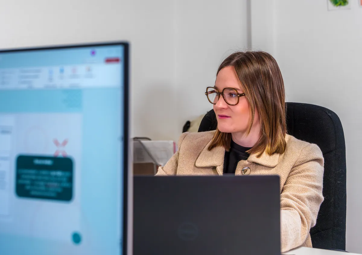 Chef de projet EcloLINK vérifiant un site web client sur son poste de travail double écran