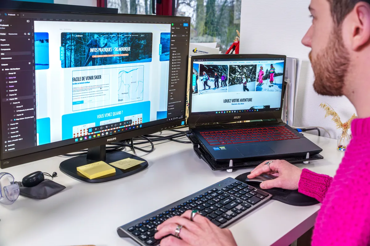 Maquette d’un site de tourisme hivernal affichée sur un écran d’ordinateur et un ordinateur portable.