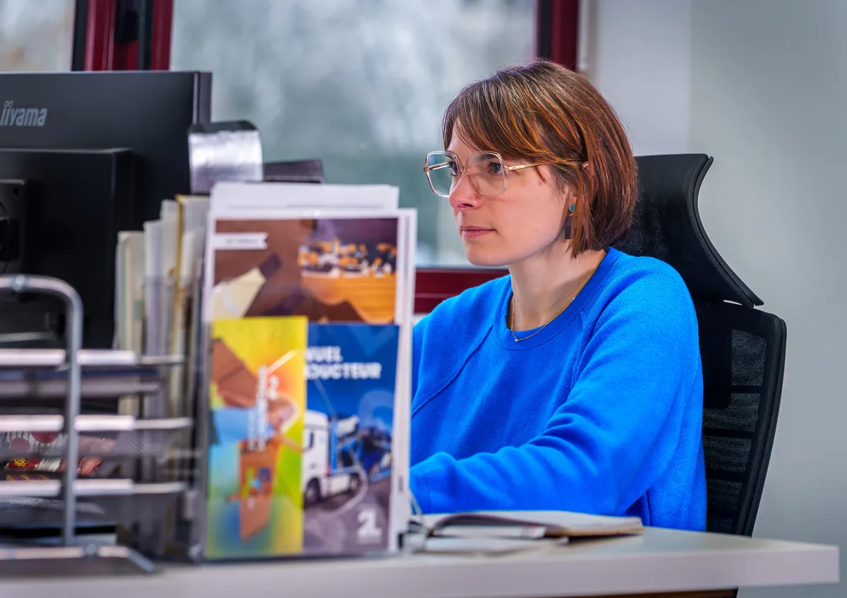 Portrait de profil d'une graphiste EcloLINK concentrée à son poste de travail