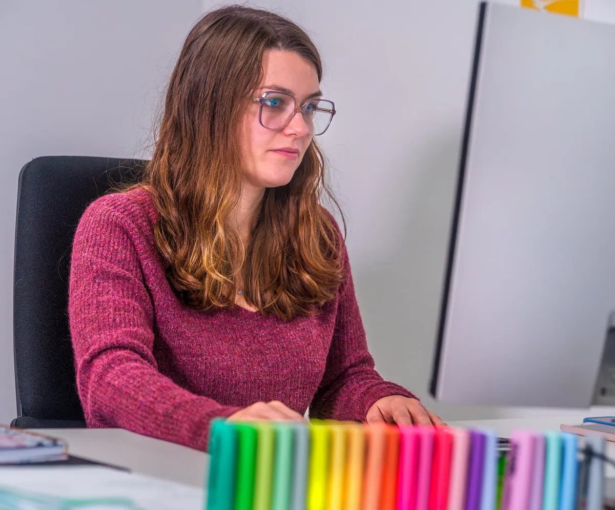 Consultante webmarketing EcloLINK à son poste de travail coloré dans les bureaux de l'agence
