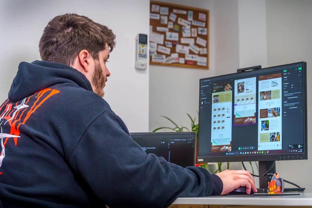 Développeur EcloLINK travaillant sur le maquettage d'un site web avec un outil de design affiché à l'écran