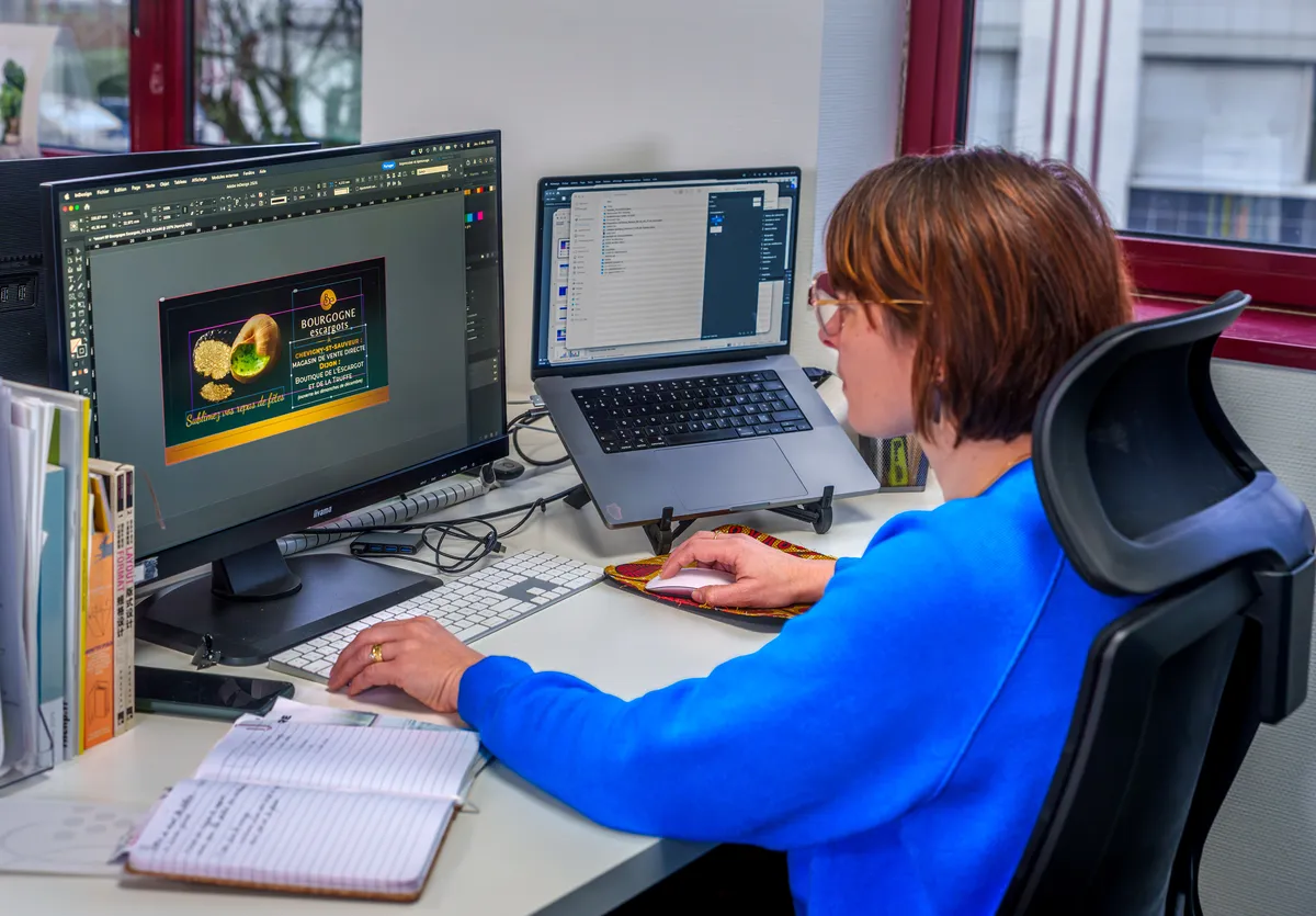 Graphiste EcloLINK créant un visuel publicitaire pour un client sur Adobe InDesign