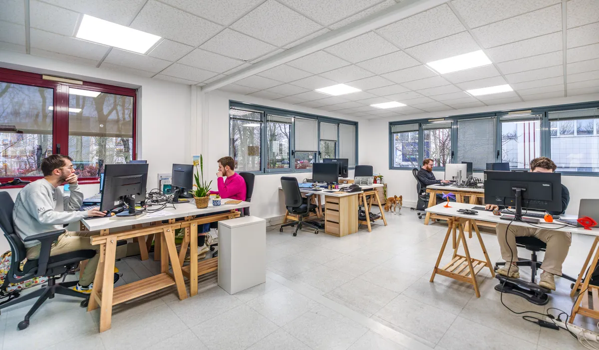 Open space de l'équipe de développement web de l'agence EcloLINK avec quatre collaborateurs à leurs postes de travail