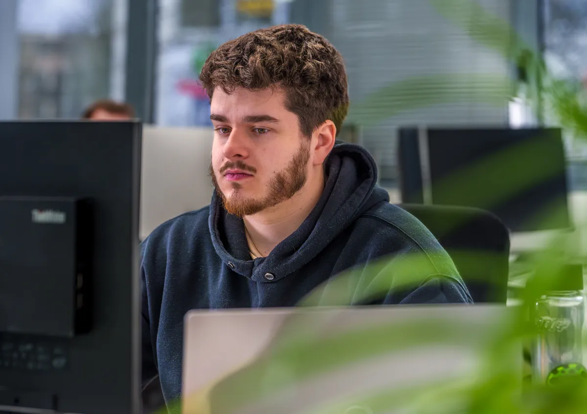 Développeur web de l'agence EcloLINK concentré sur son travail dans les bureaux de l'agence