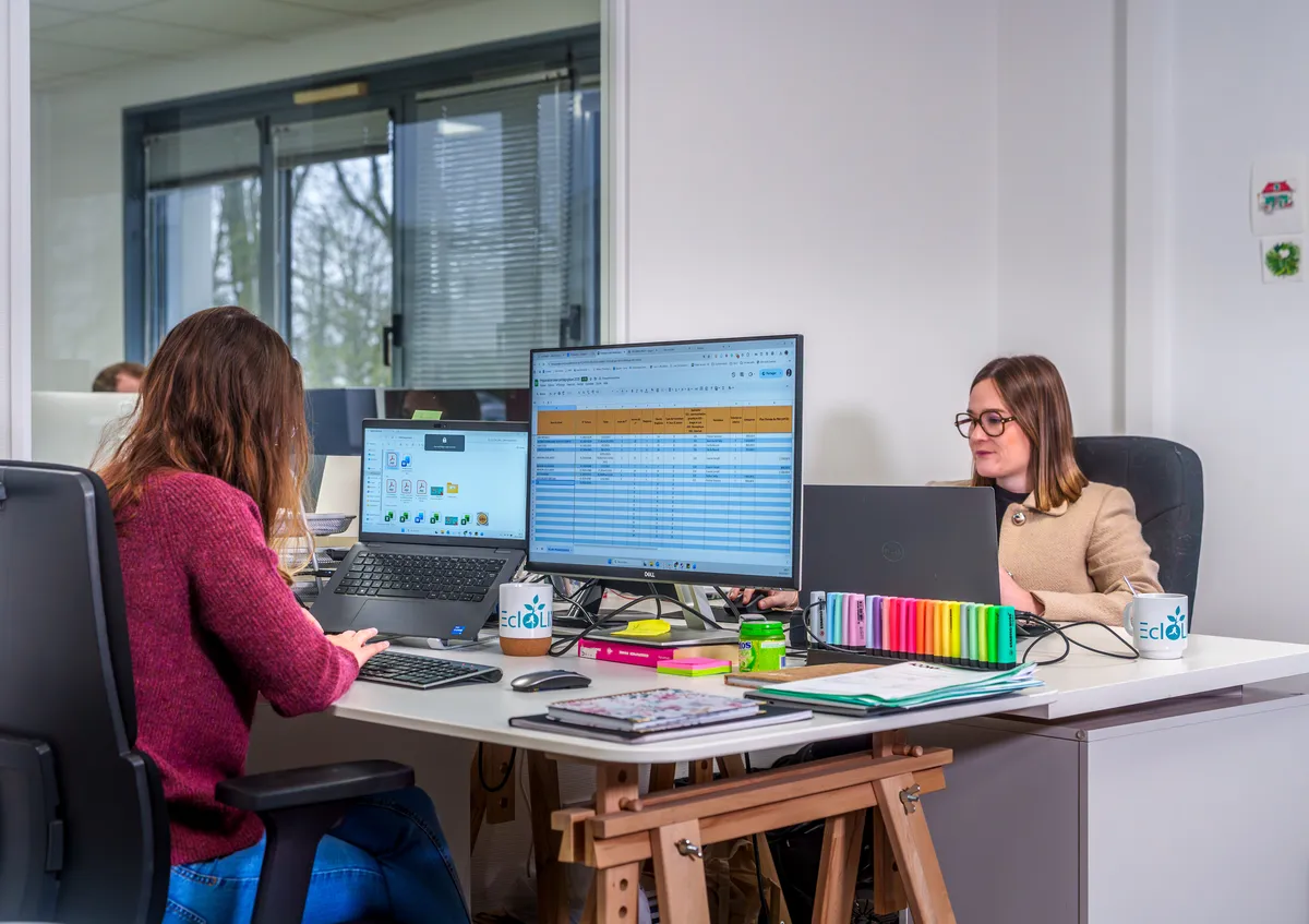 Gestion de projet et planification au bureau de l'équipe EcloLINK avec un suivi affiché à l'écran