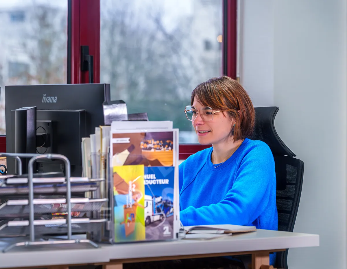 Graphiste de l'agence EcloLINK souriante à son poste de travail