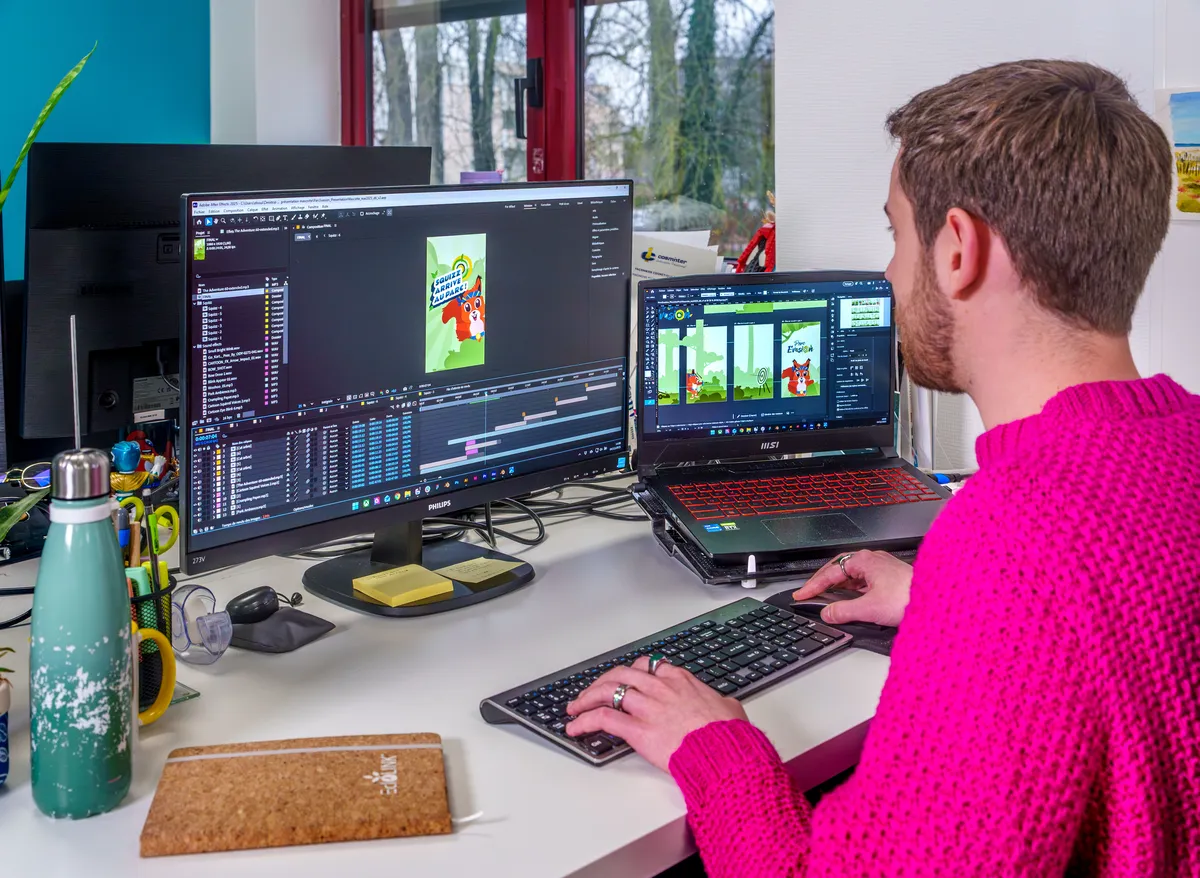 Motion designer travaillant sur une animation graphique dans After Effects avec éléments sur écran secondaire.