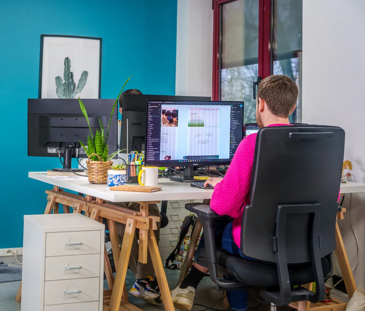 Deux collaboratrices échangeant autour d’un ordinateur portable dans un bureau.